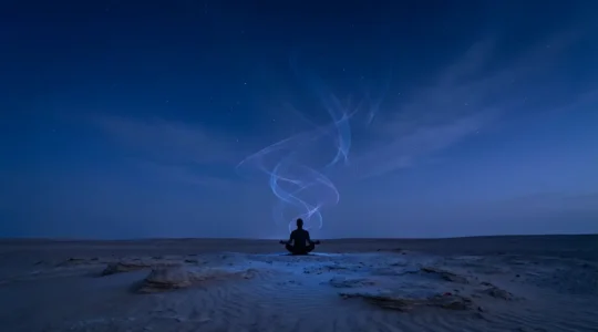 Persona meditando bajo cielo estrellado con energía luminosa ascendente